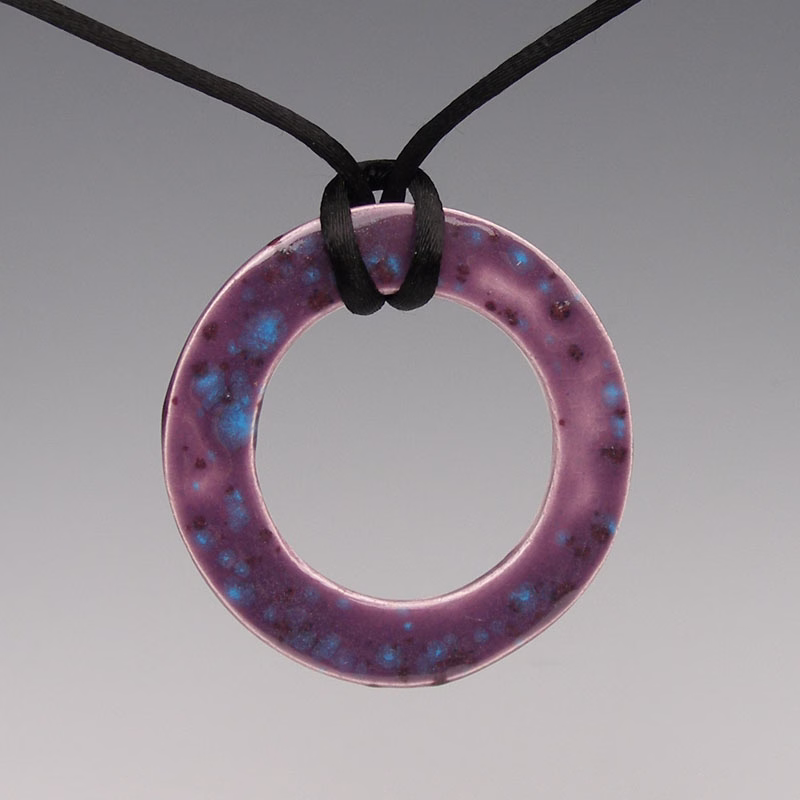 A purple ceramic pendant with blue crystalline glaze coating.