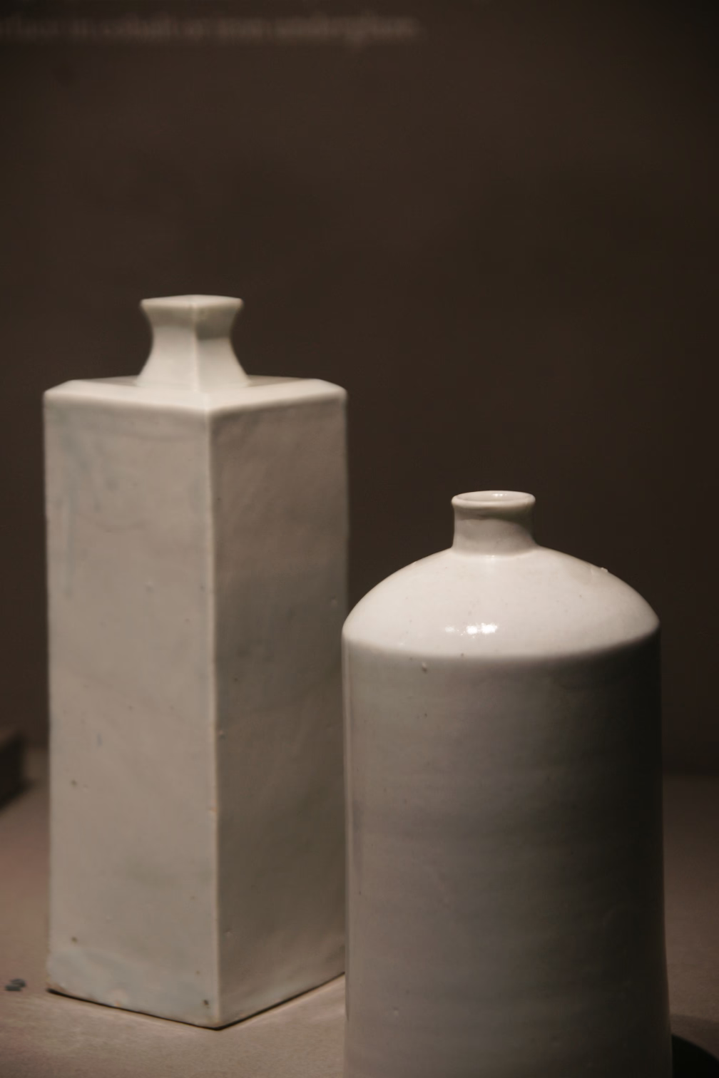 Two white porcelain vases sitting on top of a table.